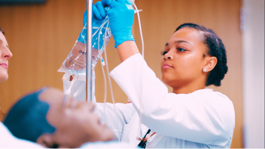 Nursing student adjusting the IV.